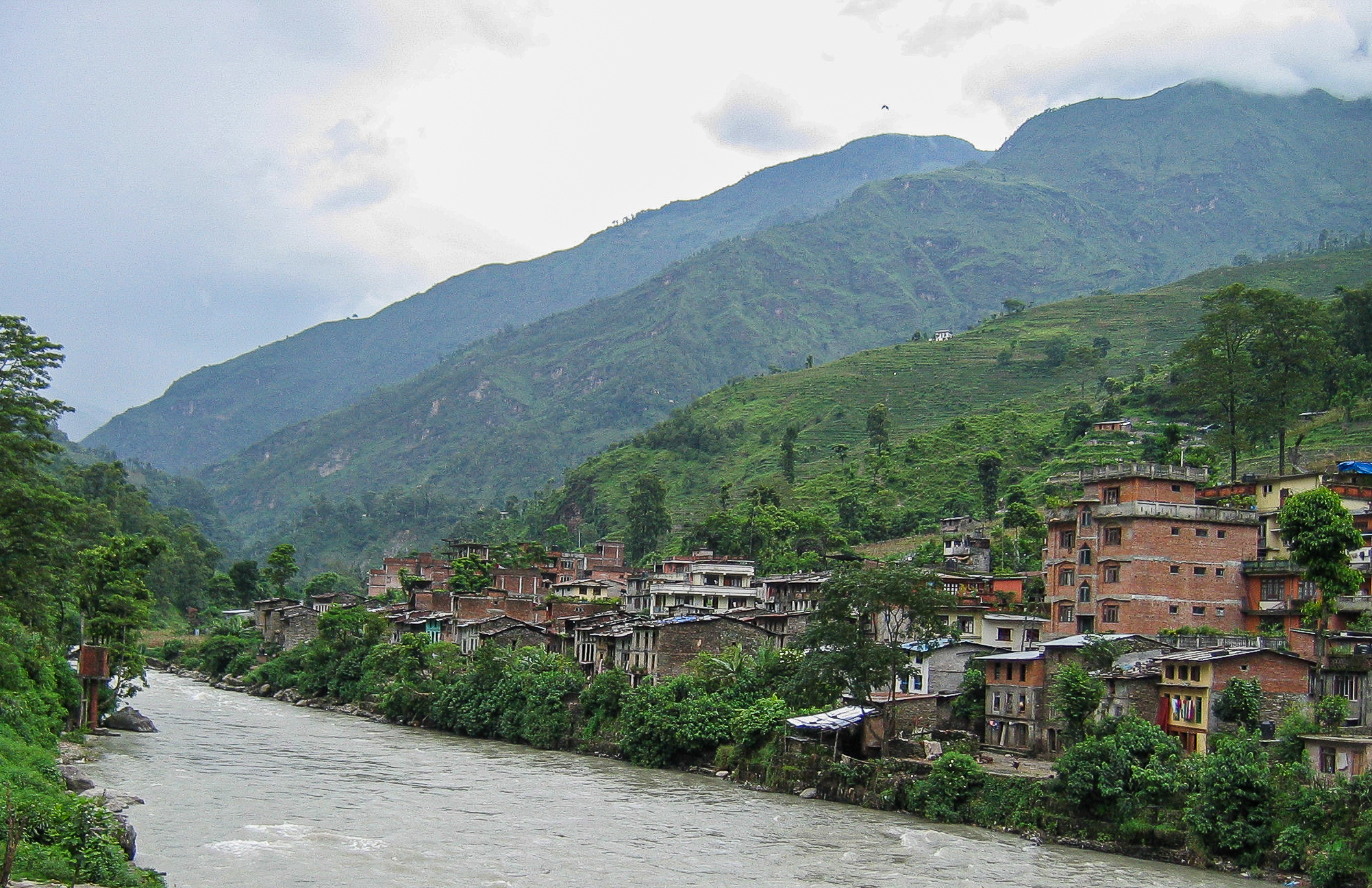 Kathmandu to Lhasa overland - Day 1 - Bahrabise - village houses on the Sunkoshi River with the mountains in the background