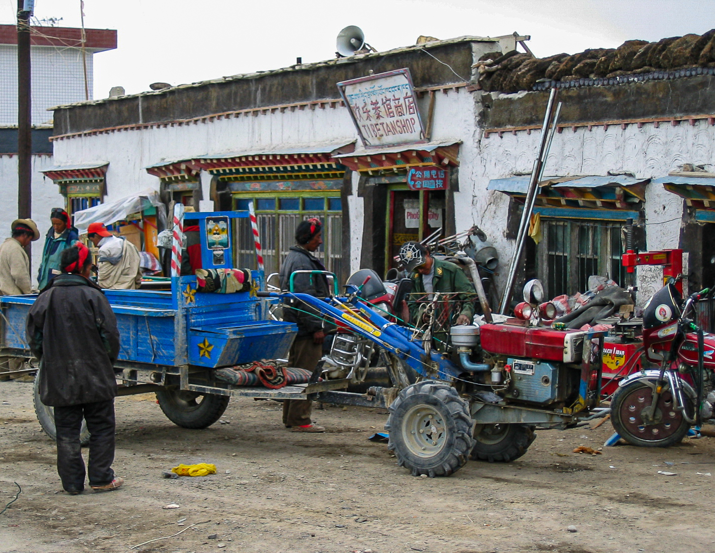 Brightly coloured vehicles at a mechanic's garage on the outskirts of Tingri - also known as Shegar.