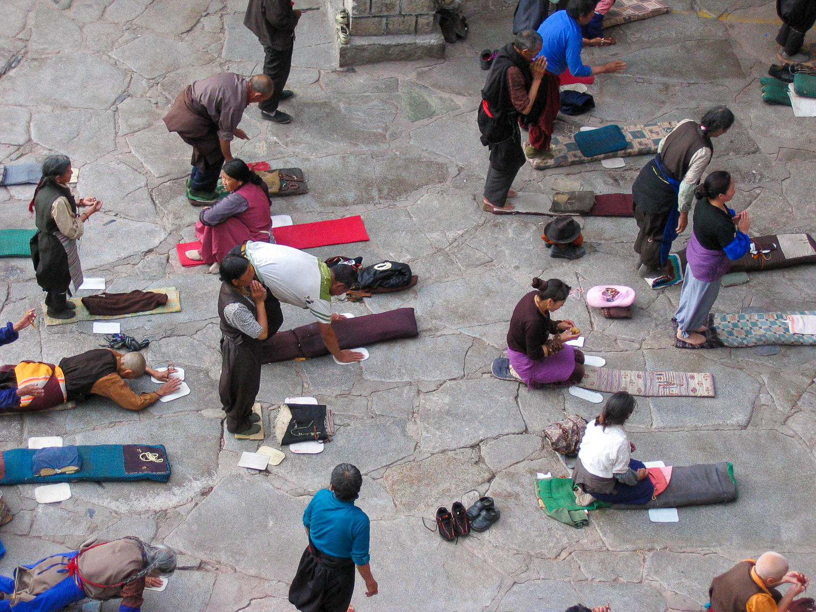 Tibetan pilgrim prostrating themselves in front of the Jokhang Temple. Lhasa. Tibet.