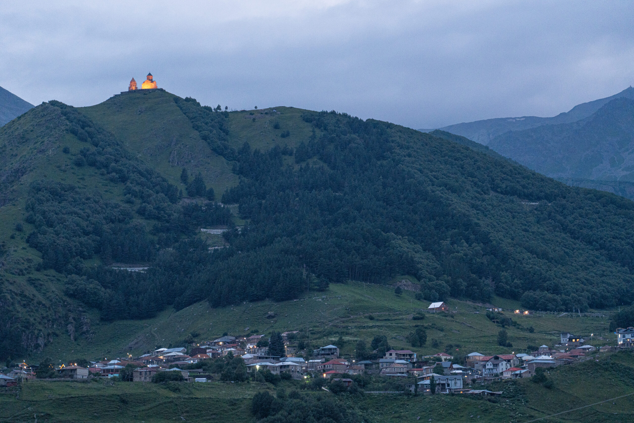 Georgia - Kazbegi - Gergeti and Gergeti Trintiy Church at nightfall