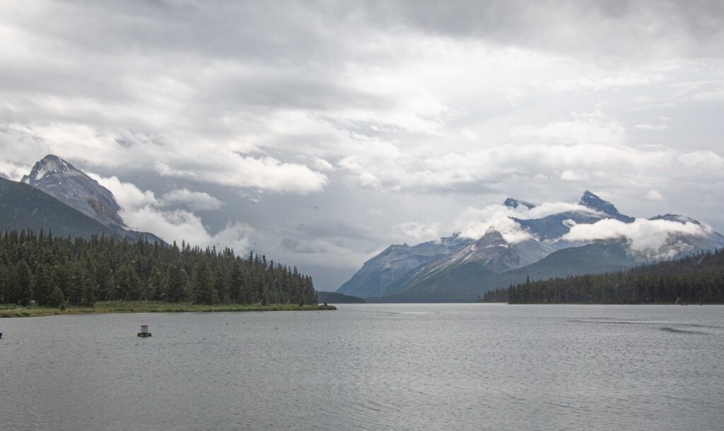 Maligne Lake with mountain peaks under cloud